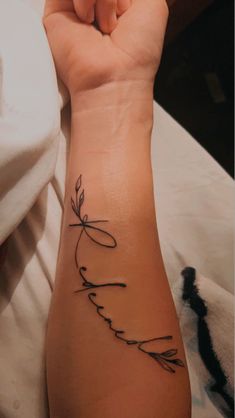 a woman's arm with a tattoo that reads love and an arrow on it