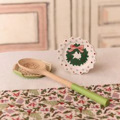 a wooden spoon sitting on top of a table next to a paper plate with a wreath