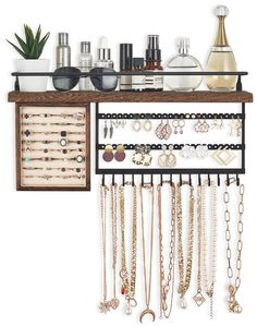 a wooden shelf with jewelry hanging from it's sides and two shelves holding various items