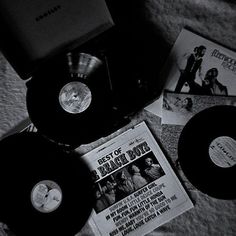 various records are laying on top of a bed