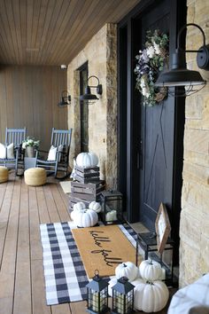 a porch decorated for fall with pumpkins and other decorations