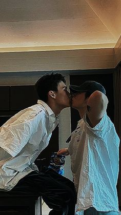 two people kissing each other in front of a mirror