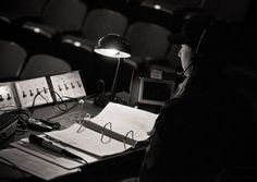 a person sitting at a desk with headphones on and papers in front of them