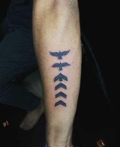 a man's arm with an arrow and two birds tattoo on the left leg