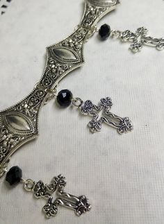 Victorian Gothic metal choker with hollow crosses and black crystal beads, ornate metal necklace, Victorian jewelry, Gothic jewelry A beautifully ornate gothic silver metal choker with Victorian hollow cross charms and black faceted crystal beads. It measures approx. 11 inches in length and has lobster clasp fastening and an extension chain, so that it can be adjusted to fit the neck. The choker is made up of 7 silver toned metal ancient style sections that have intricate detailing. A marvelous Gothic Silver Metal Body Jewelry, Gothic Metal Choker For Festivals, Ornate Metal Choker Necklace, Silver Gothic Metal Body Jewelry, Silver Gothic Body Jewelry, Silver Metal Jewelry With Black Beads, Gothic Metal Cross Pendant Jewelry, Gothic Metal Cross Jewelry, Gothic Cross Pendant Jewelry