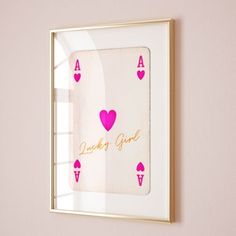 a pink and gold framed playing card with hearts on it