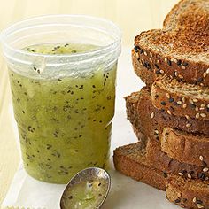 a stack of toasted bread next to a jar of green liquid