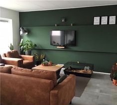 a living room filled with furniture and a flat screen tv mounted on the wall above it