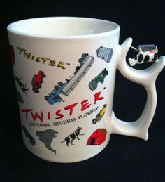 a white coffee mug with the words twister on it's side and various stickers