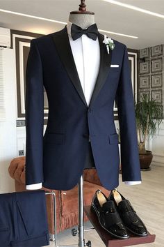 a tuxedo suit and shoes are on display in a living room with wood flooring