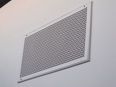 a white wall mounted air vent on the side of a building