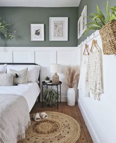 a bed room with a neatly made bed and pictures hanging on the wall above it