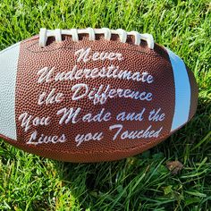 a football laying in the grass with words written on it