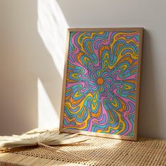 an art work is displayed on a table in front of a white wall with sunlight coming through the window