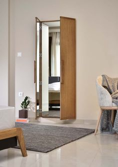 a living room with a chair, mirror and rug on the floor in front of it