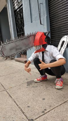 a person wearing a mask and tie kneeling on the sidewalk