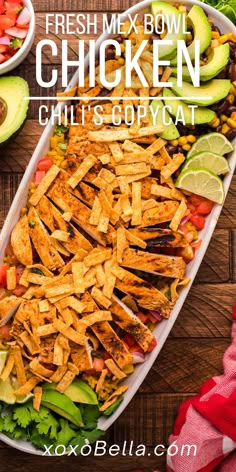 a large platter filled with taco salad and sliced avocado on the side