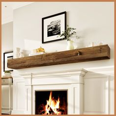 a fire place in a living room with white walls and wood trimming on the mantle