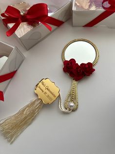 a mirror with a tassel hanging from it's side next to some gift boxes