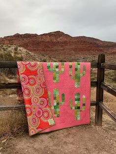 two quilts hanging on a fence in the desert