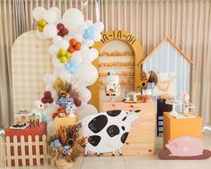 a room filled with lots of decorations and balloons on the wall next to a cow