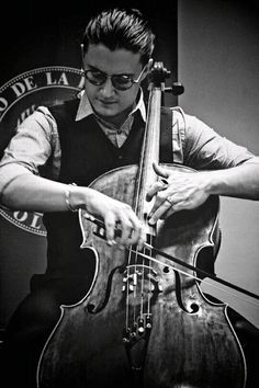 a man playing an instrument in front of a microphone