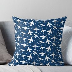 an airplane pattern on a blue background is featured in this throw pillow that has been placed on a couch