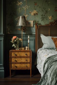 a bedroom with floral wallpaper and an old dresser in the corner, next to a bed