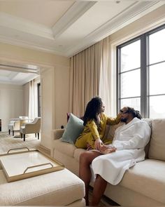 a man and woman sitting on a couch in a living room next to each other