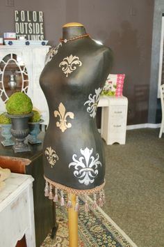 a black mannequin with gold fleur de lis on it