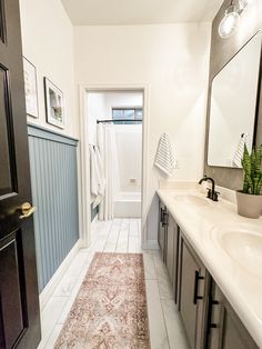 a bathroom with two sinks and a rug on the floor