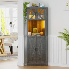 a tall wooden cabinet sitting in the middle of a living room next to a dining room table