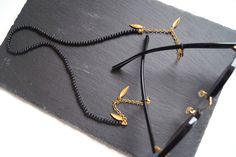 "Women Boho Black Sunglasses Strap with Silver or Gold Leaves. This cute beaded glasses chain will complement a daily chic outfit in the best stylish way! An elegant eyeglass holder designed with frosted black glass beads with a dainty steel-plated chain and decorated with tiny leaves makes a statement. Add it to your jewelry collection for that dash of elegance or make an exciting gift to her that will get lots of compliments! ‣ Steel-plated 3,5mm thickness chain. ‣ Steel-plated parrot clasps, Boho Glasses, Beaded Glasses Chain, Unique Eyeglasses, Beaded Glasses