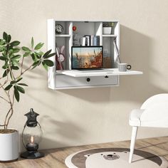 a white wall mounted shelf with a tv on it's top and shelves below