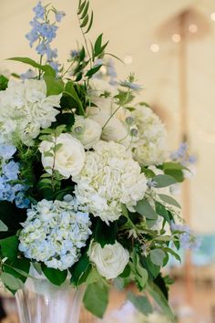 a vase filled with white and blue flowers