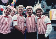 a group of men in red and white striped vests standing next to each other