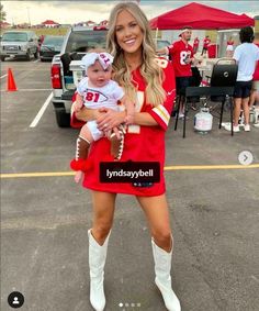 a woman in a football uniform holding a baby