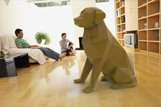 two men sitting on the floor in front of a dog statue