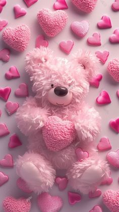 a pink teddy bear surrounded by hearts