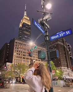 a woman standing on the corner of west 35th street