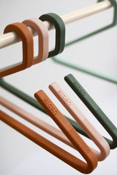 four different colored handles hanging from a rack