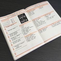 an open planner book on top of a wooden table