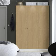 an image of a bedroom setting with closets and clothes hanging on the wall in it