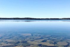 the water is clear and blue with rocks in it