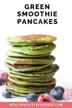 green smoothie pancakes stacked on top of each other with blueberries and raspberries