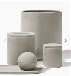 an assortment of grey objects on a white surface with one round object in the middle