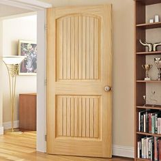 an open door in a living room next to a book shelf with books on it