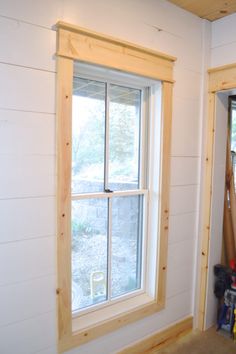 an empty room with a window and tools on the floor