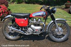 a red and black motorcycle is parked in the driveway