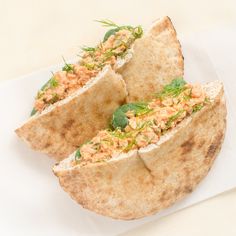 two pita breads with meat and vegetables on them sitting on top of a piece of paper